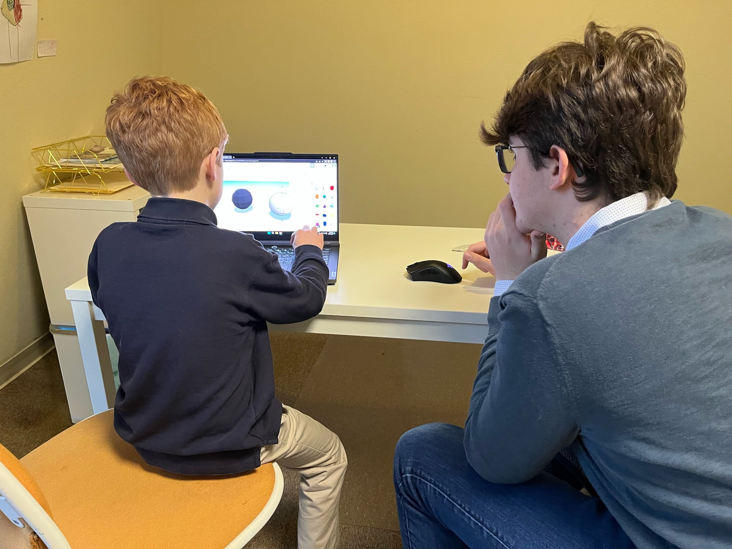 A Maker Math tutor works one-on-one with a student on 3D CAD modeling, designing a custom math manipulative.